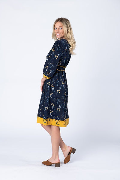 Side view of pretty navy dress with yellow flowers and accents.
