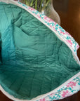 Inside view of pocket in pink and teal floral travel pouch.