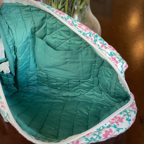 Inside view of pocket in pink and teal floral travel pouch.