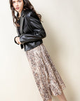 Pleated midi skirt in snake skin print paired with black leather jacket.