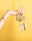 Miyuki bracelets with colorful glass beads.Bunch of miyuki bracelets held by model.