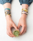 Colorful glass bracelet. Arms wearing stacks of miyuki bracelets.