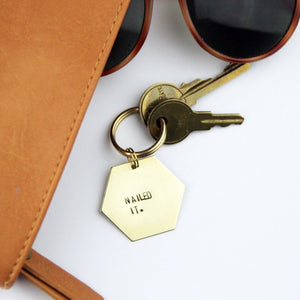 Hand stamped brass hexagon keychain that reads "Nailed It."