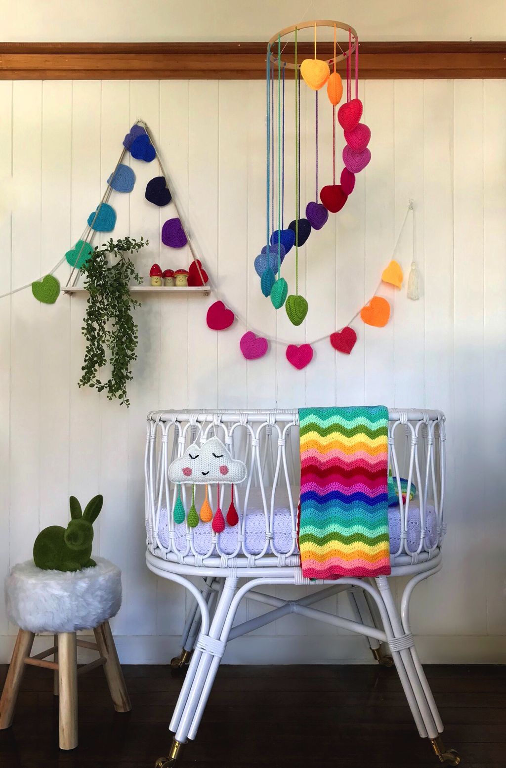 Unique baby gifts. Rainbow heart mobile hanging over basinet.