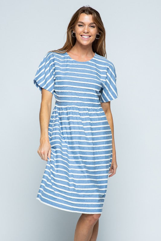 Woman&#39;s short sleeve midi dress with short sleeve. Blue cotton with white stripes and pockets.