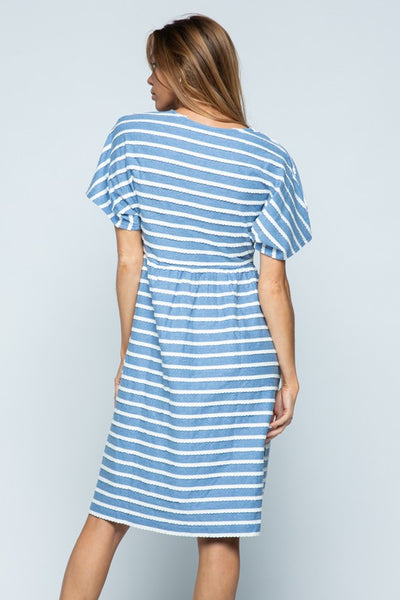Back view of blue cotton midi dress with white stripes. Short sleeves.