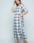 Side view of elbow length sleeve grey and white buffalo check midi dress with pockets.