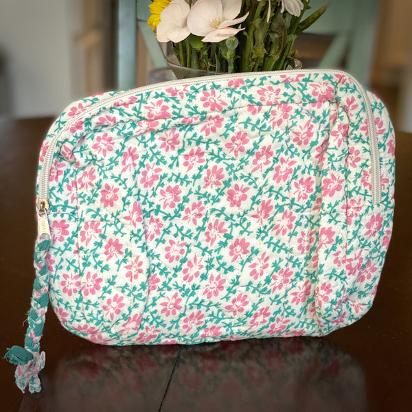Pink and teal floral patterned cotton travel pouch for women.