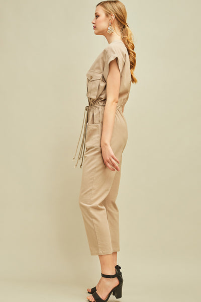 Side view of women's cargo jumpsuit in khaki with straight leg, check and side pockets, and drawstring waist.