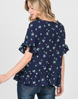 Back view of navy floral print, loose fit peplum top with short ruffle sleeves.