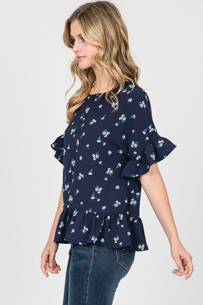Side view of short ruffle sleeve peplum top in navy floral print.