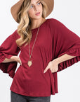 Burgundy knit top features full caped ruffle flutter sleeves and round neck.