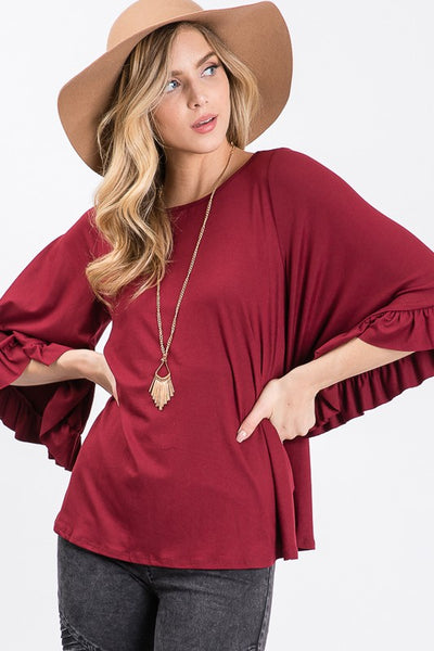 Burgundy knit top features full caped ruffle flutter sleeves and round neck.