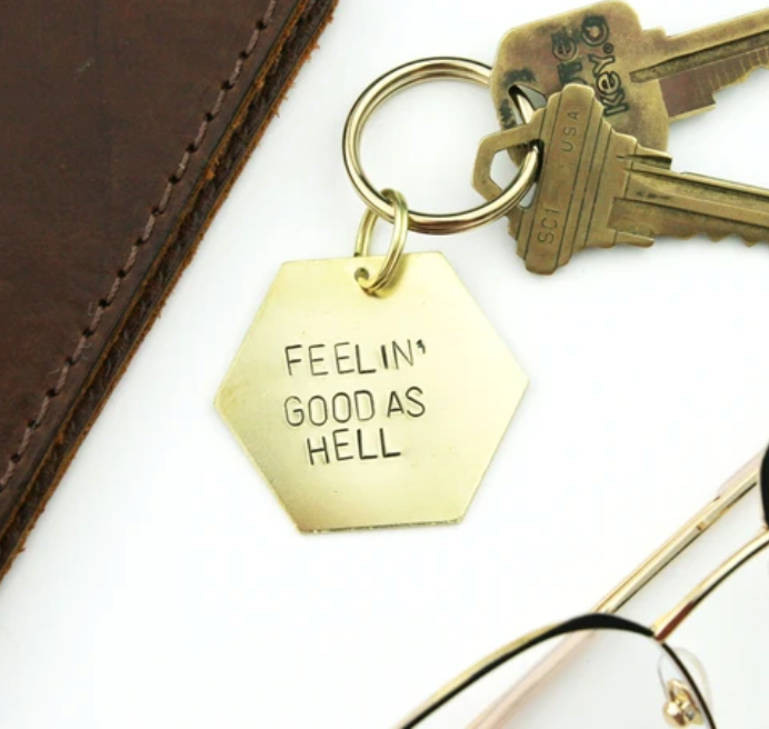 Brass hand stamped hexagon keychain that reads "Feelin' Good as Hell".