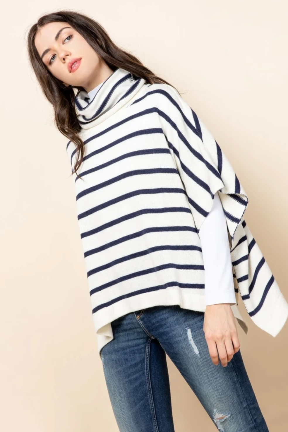 Ivory turtleneck poncho with horizontal navy stripes.