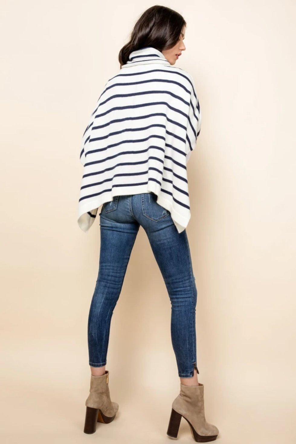 Back of ivory and navy striped turtleneck poncho sweater for women.