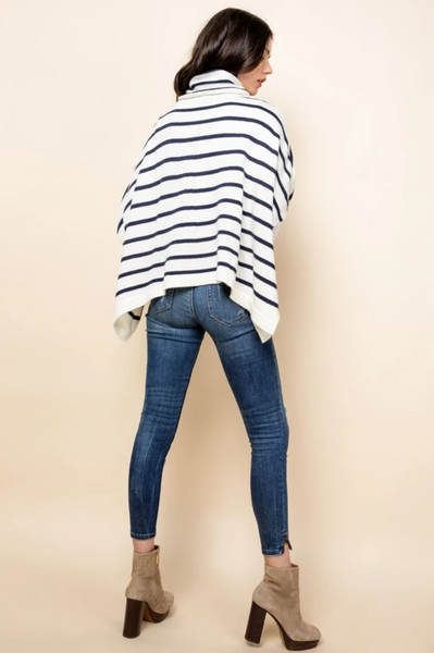 Back of ivory and navy striped turtleneck poncho sweater for women.