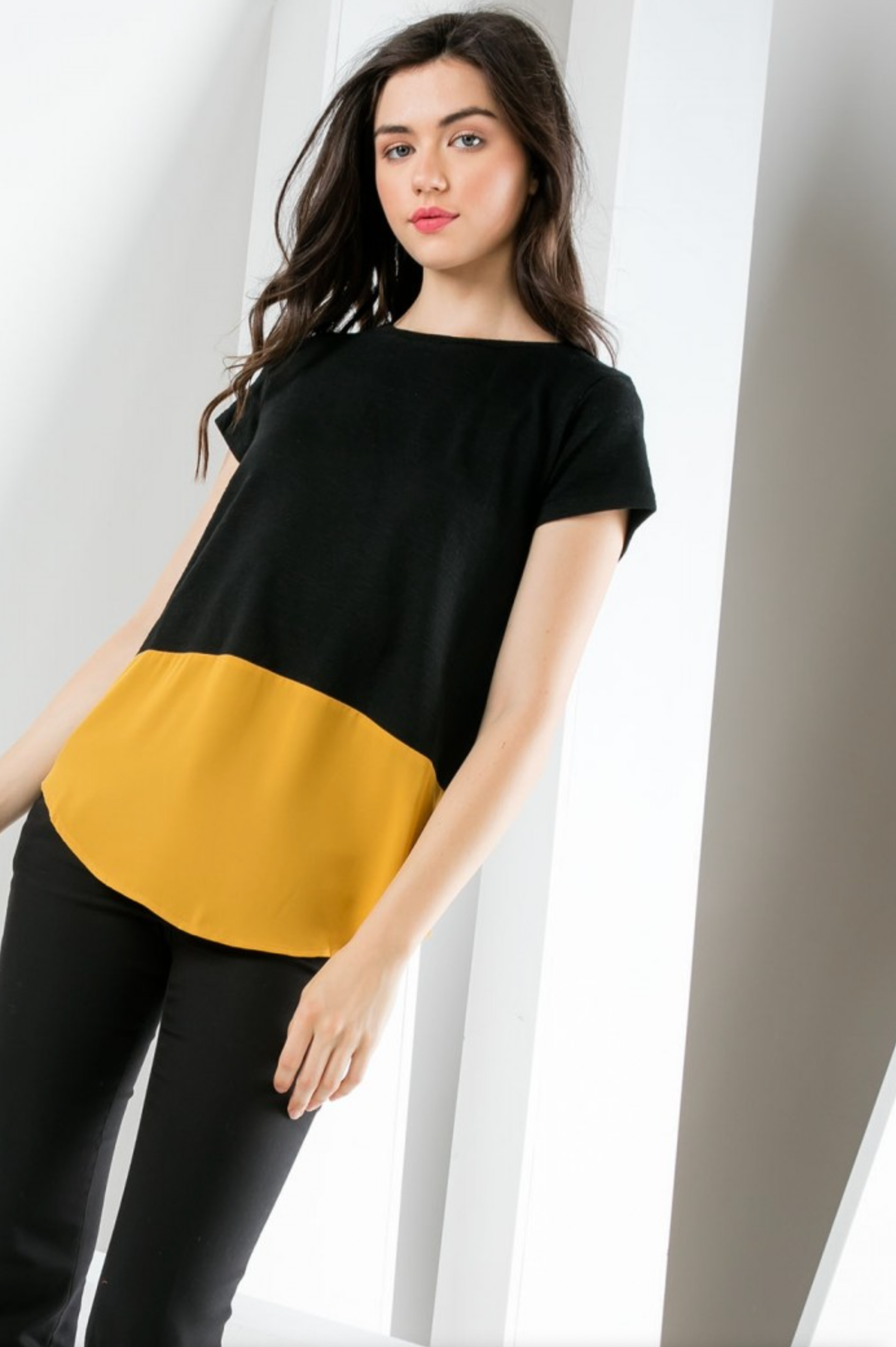 Women&#39;s black short sleeve knit top with gold poly contrast hem.