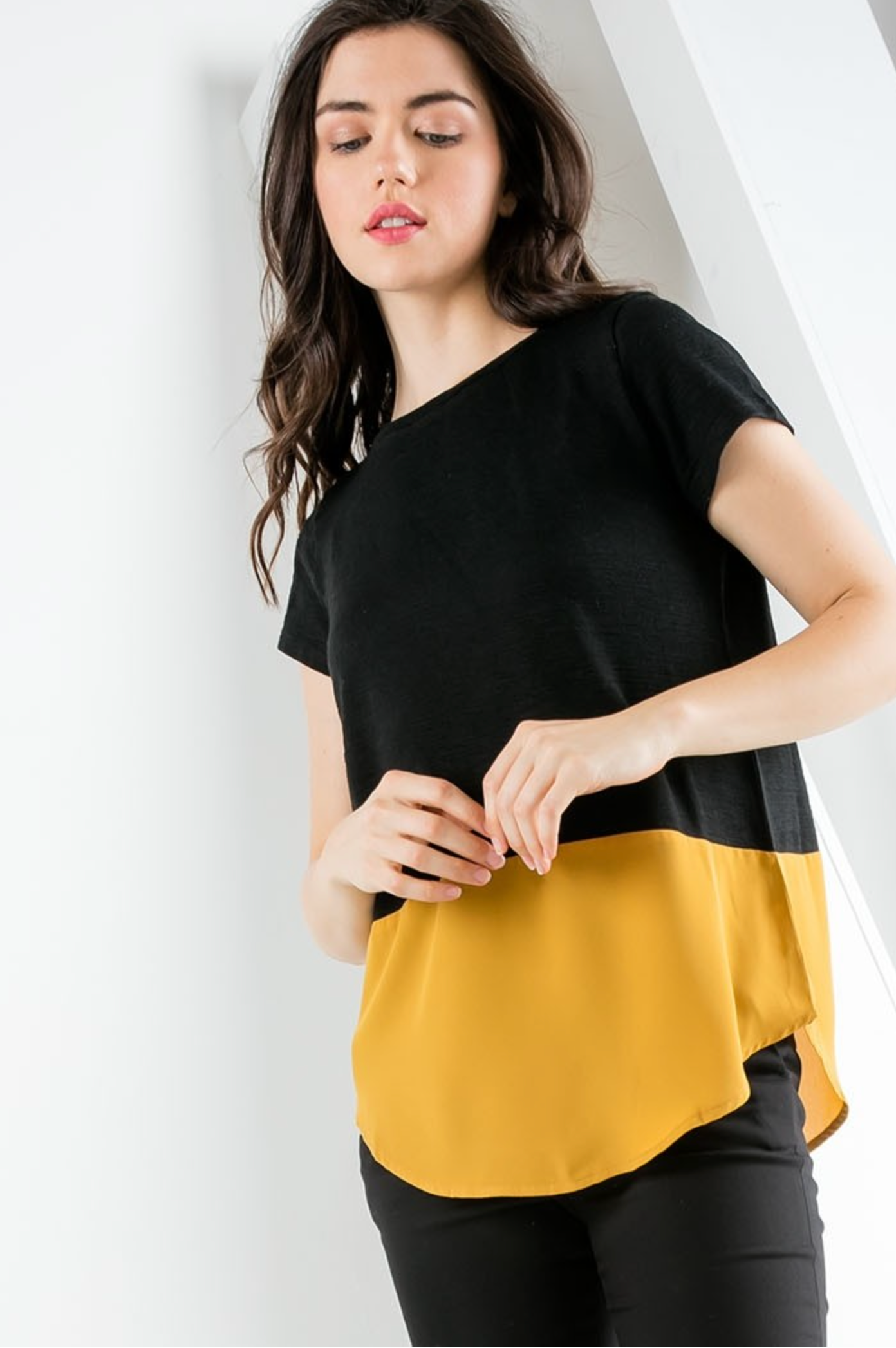 Women&#39;s short sleeve top with contrast hem in black and gold.