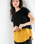 Women's short sleeve top with contrast hem in black and gold.