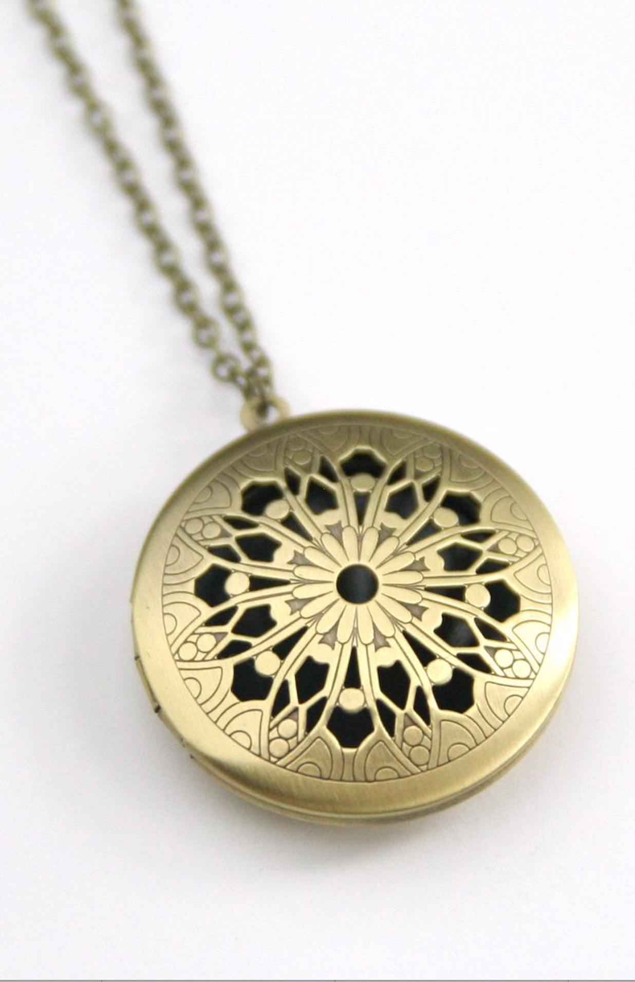 Vintage style locket in round brass filigree.