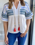 Blue and green embroidered shirt with colorful tassels and drop shoulder paired with jeans.