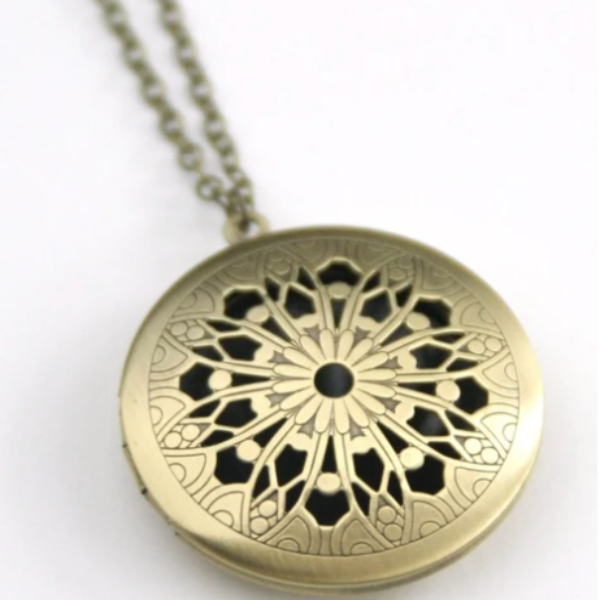 Vintage style locket in round brass filigree.