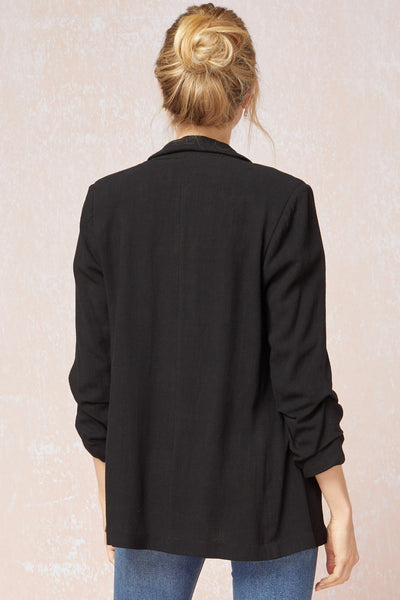Back view of Women's black blazer with scrunched sleeves. Linen.