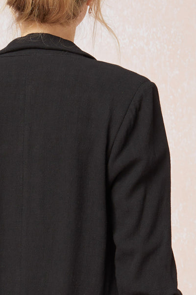 Close up of back of Women's black blazer with scrunched sleeves. Linen.