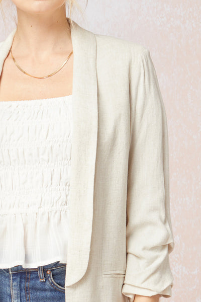 Close up of front lapel on Women's white blazer with scrunched sleeves. Natural linen color. Summer blazer.