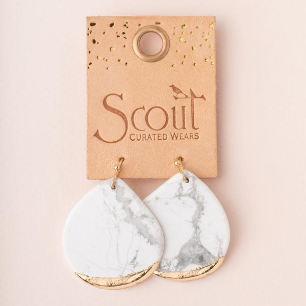 Large stone earrings dipped in gold on leather display card.
