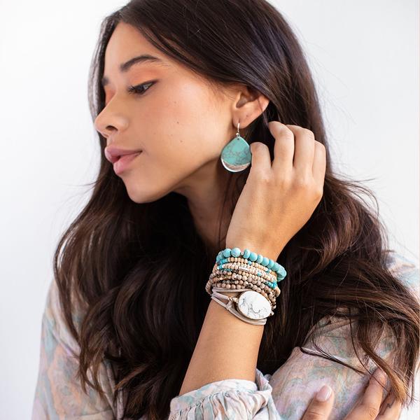 Large stone earrings in turquoise dipped in silver shown on model.