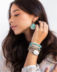 Large stone earrings in turquoise dipped in silver shown on model.