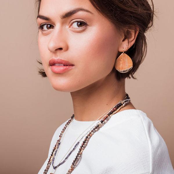 Model wearing stone teardrop dipped earring.