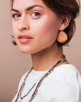 Model wearing stone teardrop dipped earring.