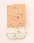 Stone hoop earrings in howlite and gold on leather display card.