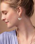 Stone hoop earrings in opalite and gold on model.