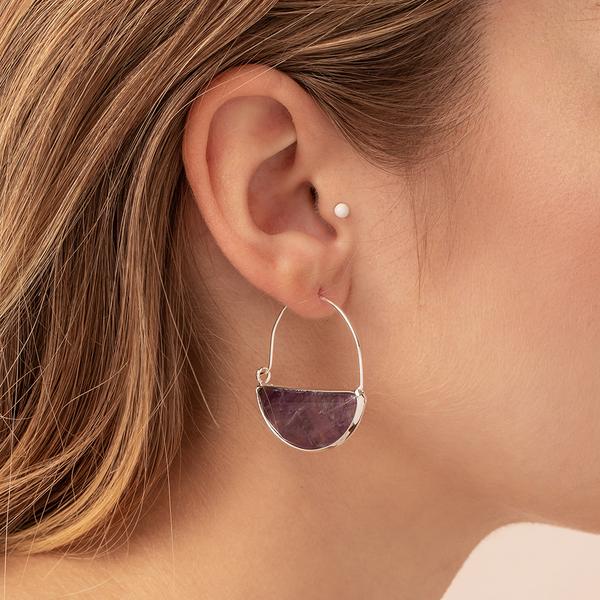 Stone hoop earrings in amethyst and silver on model.