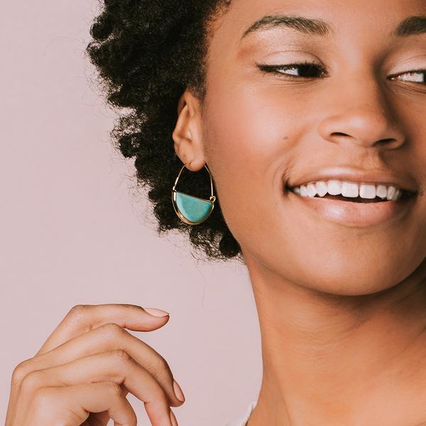 Stone hoop earrings in turquoise on model.