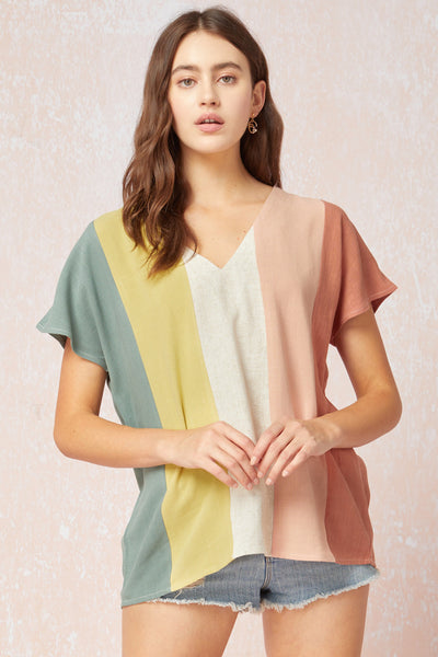 Women's linen top. Colorblock vertical stripes with v-neck and short sleeves. Shown untucked with denim shorts.