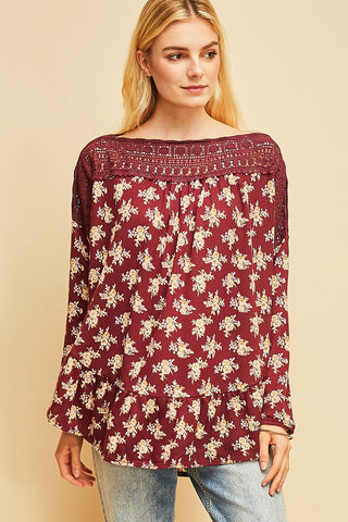 Long sleeve boho top with crocheted neckline in burgundy floral pattern.