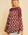 Boho top with crocheted neck and shoulder with long sleeves in burgundy floral. Ruffle along rounded hemline.