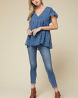 women's lightweight top - blue v-neck with ruffle sleeve hanging past hips paired with blue jeans.