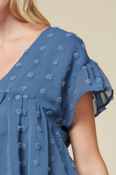 Close up of front of women's lightweight top - blue v-neck with ruffle sleeve