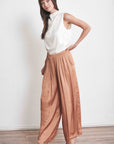 Satin feeling ivory sleeveless top with draped neck tucked into dressy pleated slacks and delicate heels.