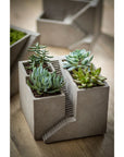 Unique planters and pots. Cement architectural designed pot with three planters shown with succulents.