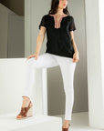 Embroidered black top. Paired with white denim and  and brown platforms.