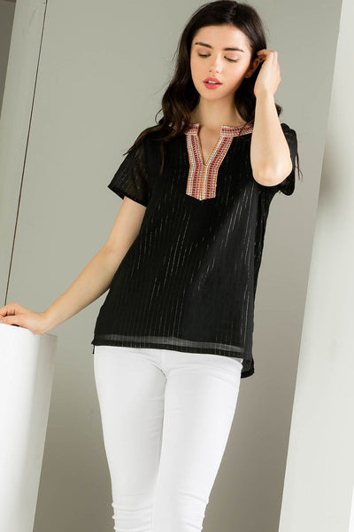 Embroidered black top. Paired with white denim.
