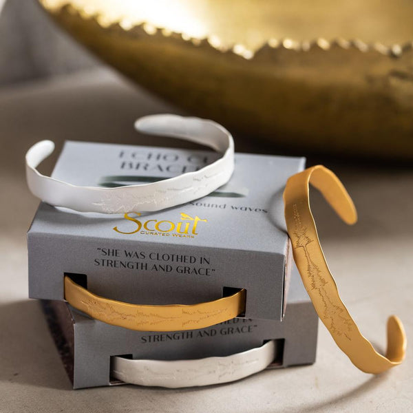 Unique Jewelry with Meaning for Women. Stacks of gold and silver bracelets with sound wave etched on outer edge meaning "She was clothed in strength and grace."