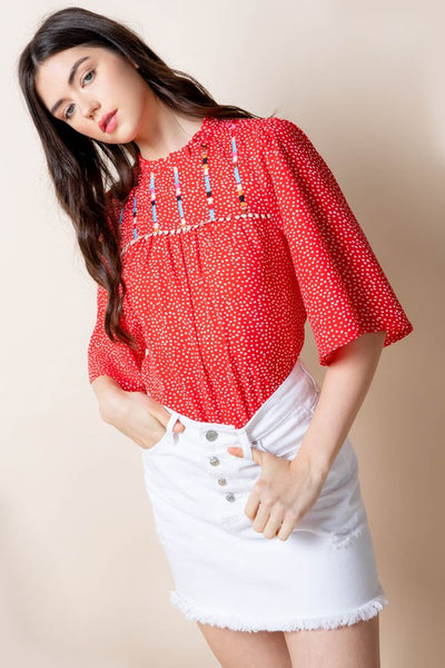 Close up of embroidered bell sleeve blouse.